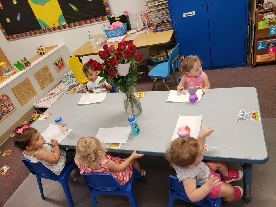 Children sitting at a table in a classroom