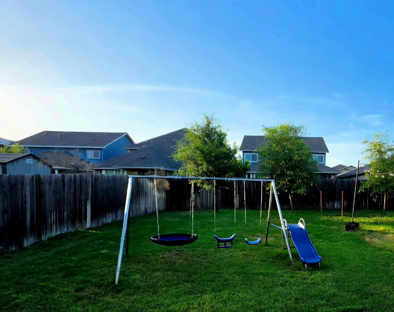 Swing set with slide in a residential backyard
