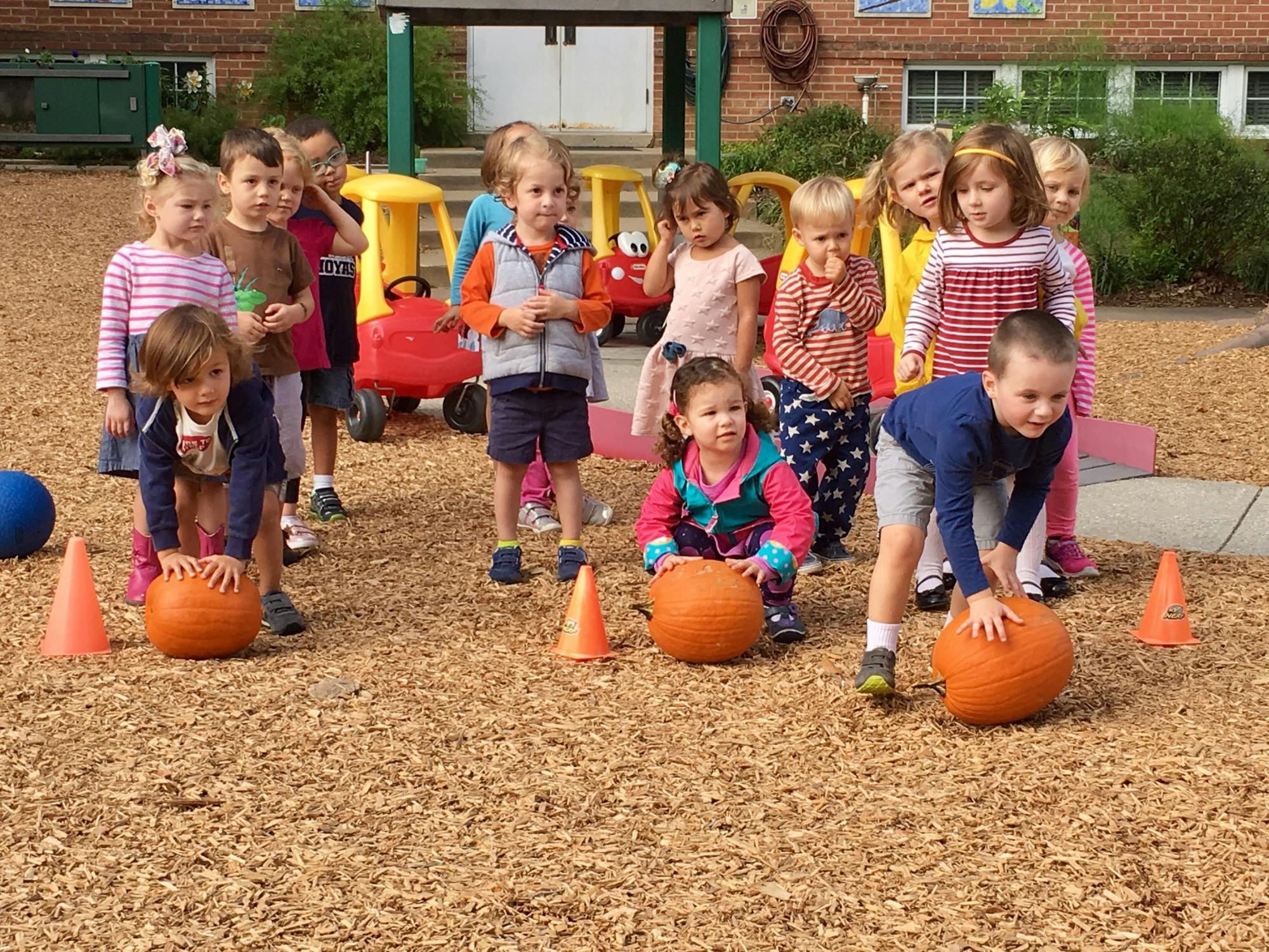 Children playing with pumpkins outdoors