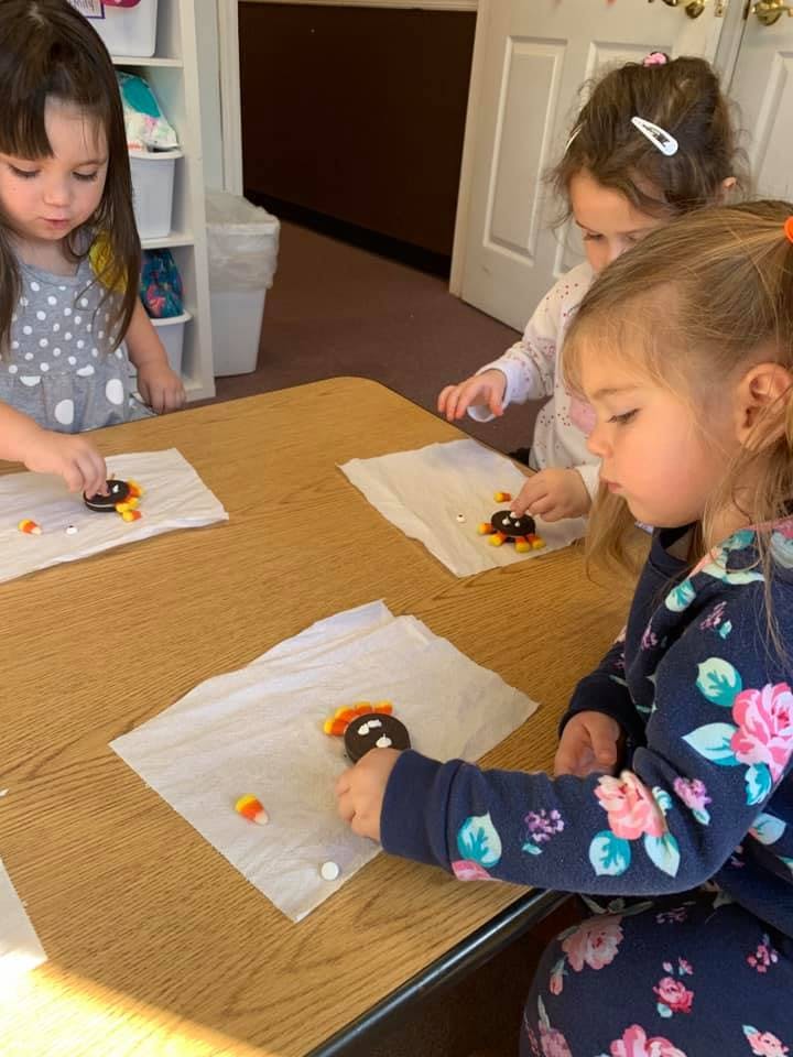 Three children decorating cookies at a table
