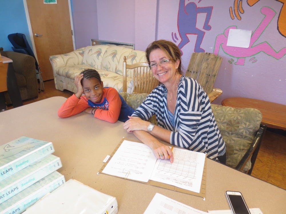 Adult and child sitting at a table with open books