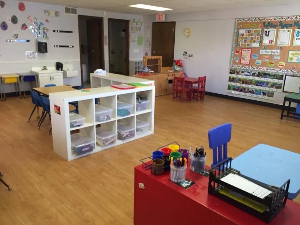 Empty classroom with tables, chairs, and storage units