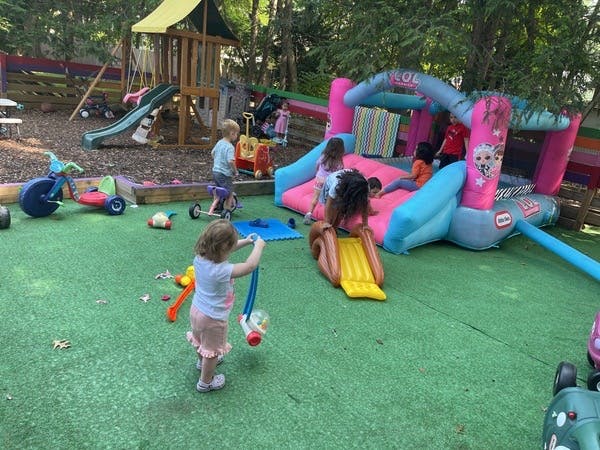 Children playing on an inflatable bounce house and playground