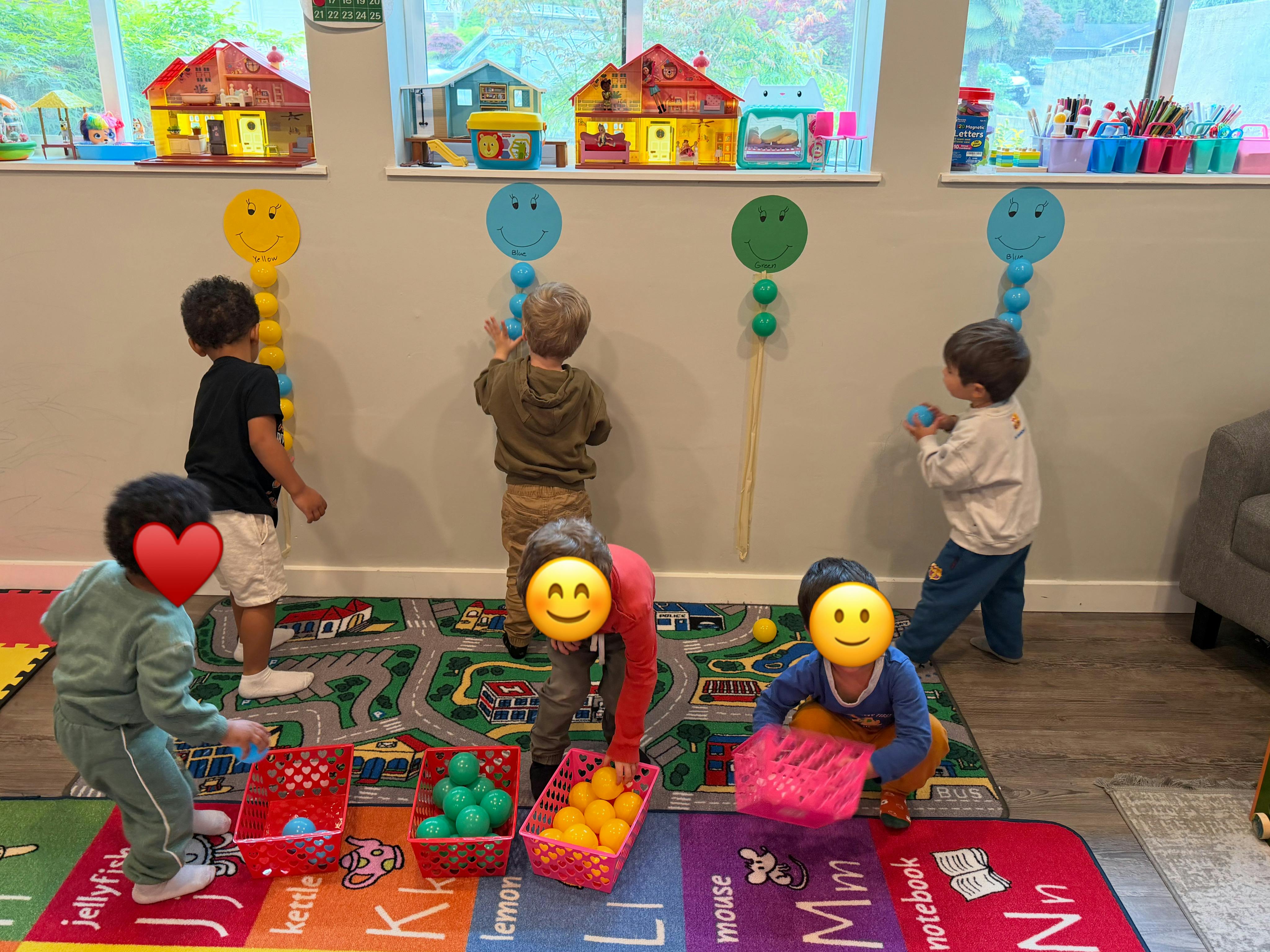 Children playing with colorful balls and baskets in a room with toy houses