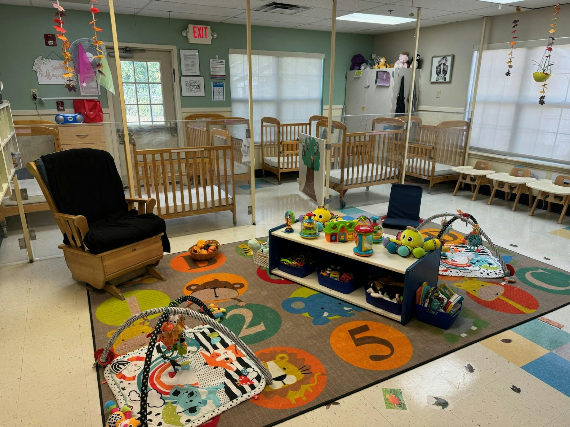 Cribs, play mats, and toys in an infant care room