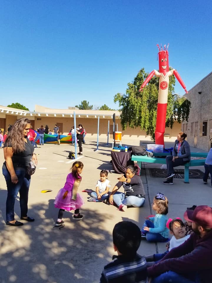 People and children gathered outdoors with an inflatable tube man