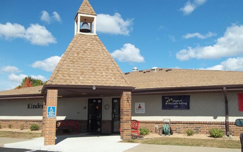 A beige building with a bell tower and an accessible entrance, wheelchair-friendly entrance