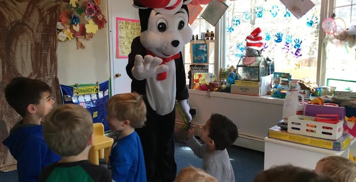 Mascot character interacting with children in a room