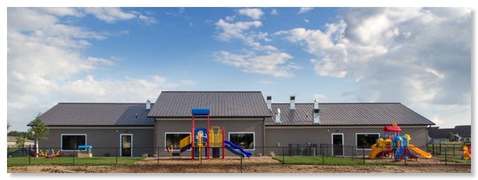 Building with playground equipment in front