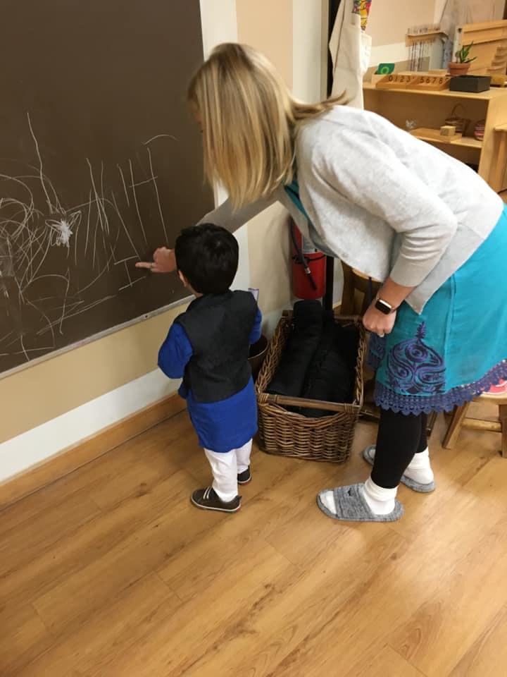 Adult and child drawing on a chalkboard