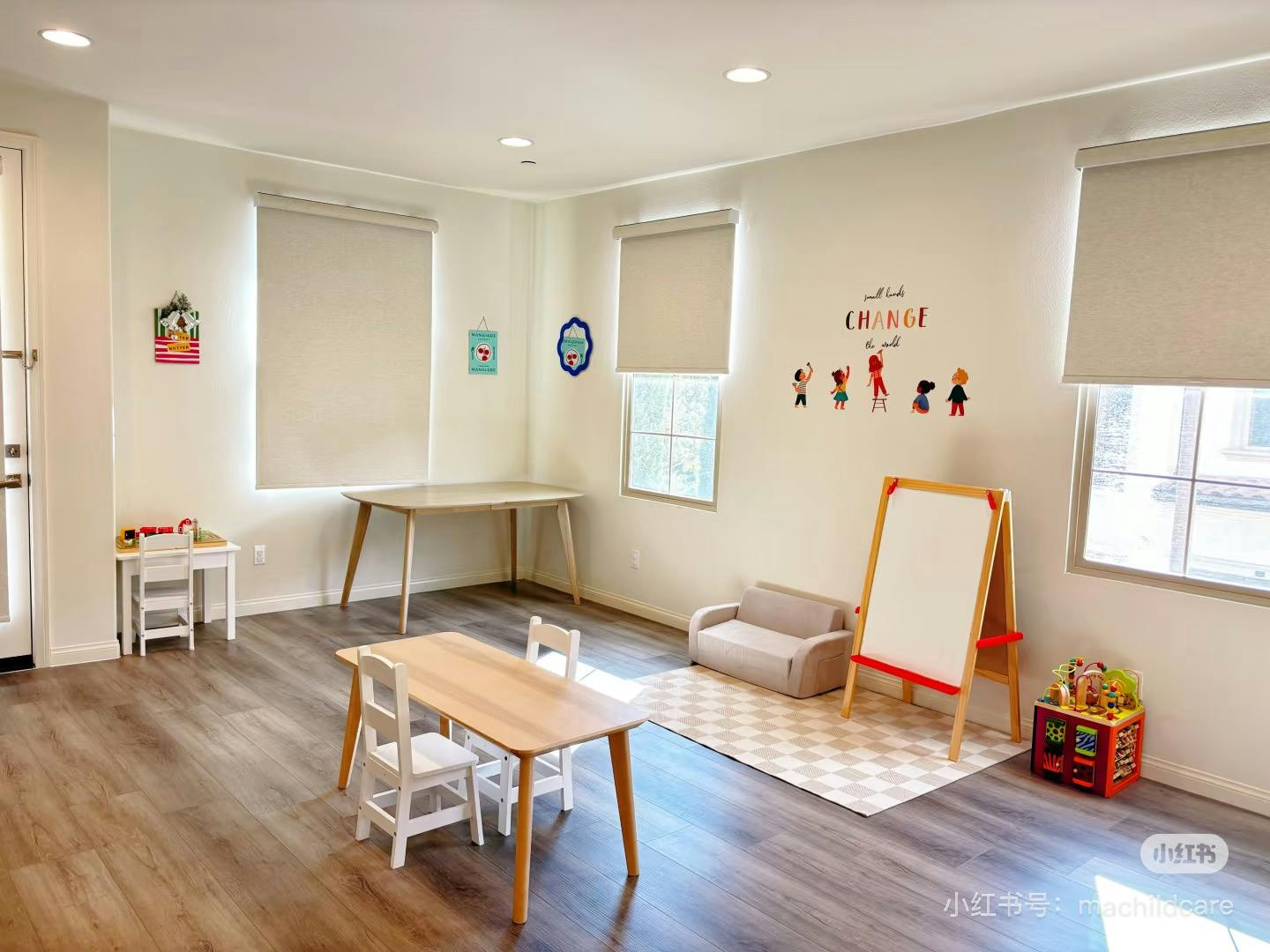 Playroom with small tables, chairs, sofa, and easel