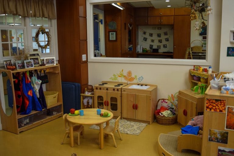 Playroom with small table and chairs, toy kitchen, and coat rack