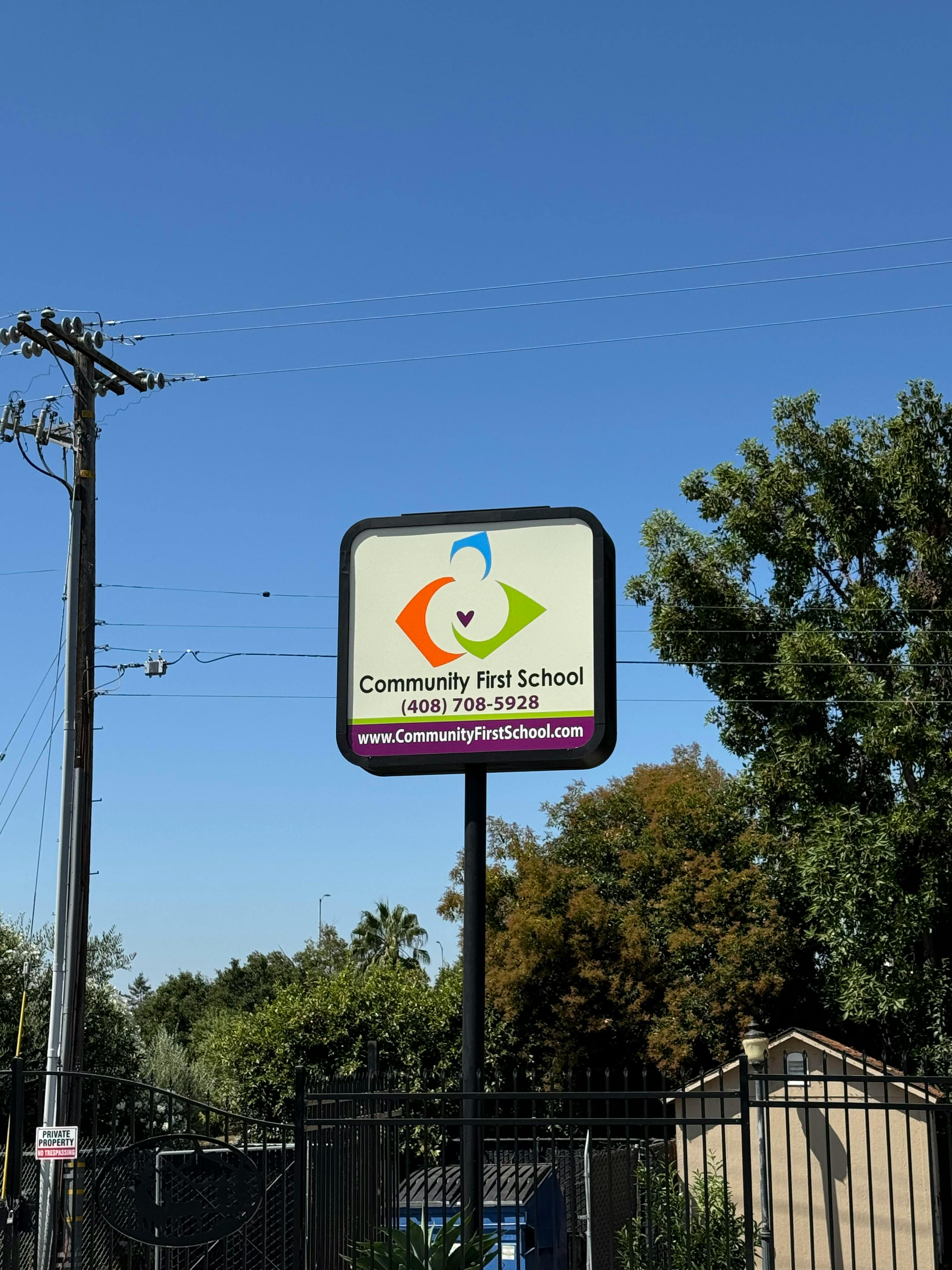 Community First School sign with logo, phone number, and website