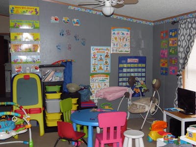 A room with children's furniture, toys, and educational posters on the walls