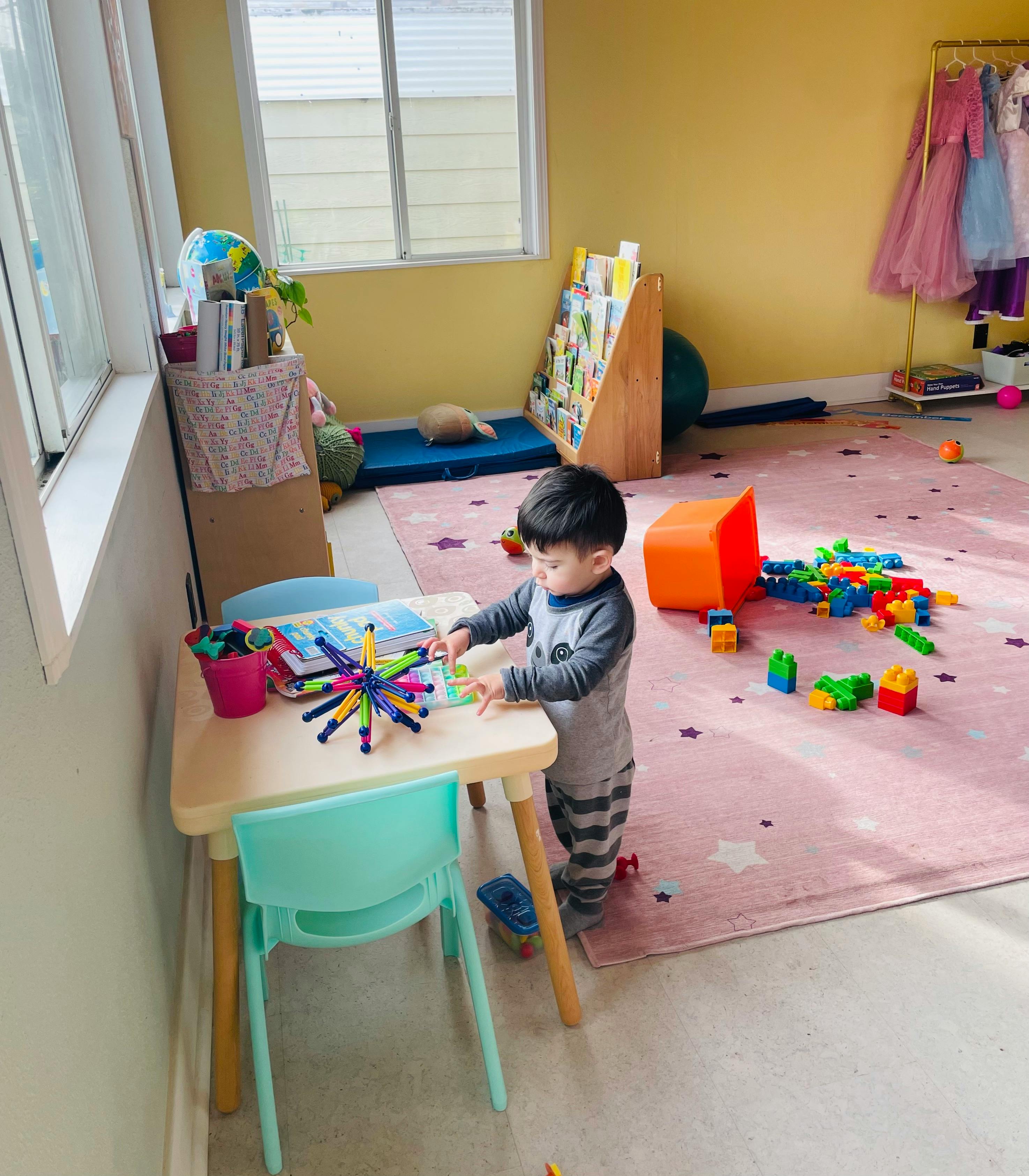 Child playing with toys at a small table in a room