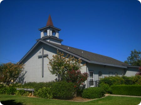 Church building with a steeple and a cross on the facade