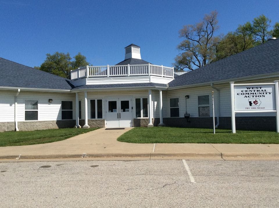 White building with a cupola and a sign that reads "West Central Community Action"