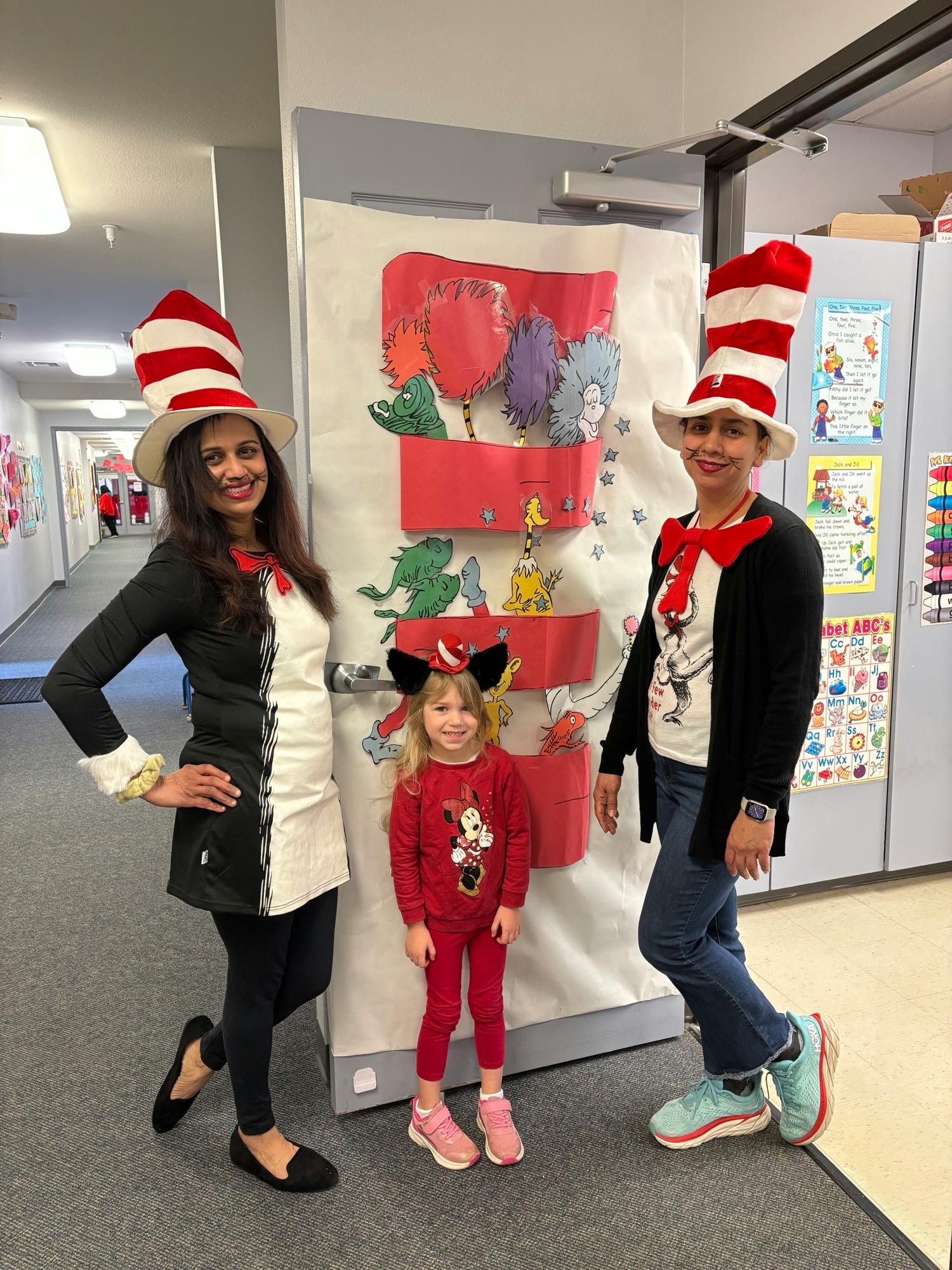 Two people and a child in costumes with tall striped hats