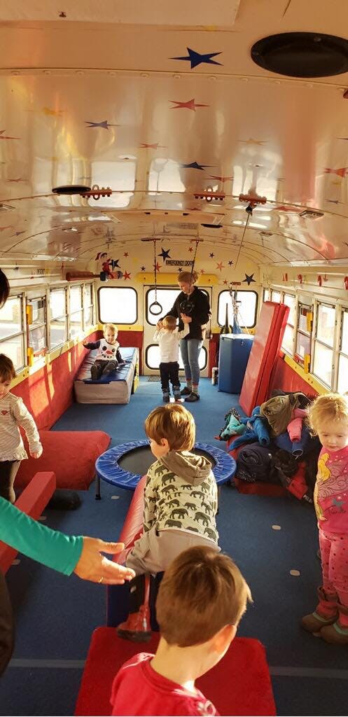 Children playing inside a bus converted into a play area