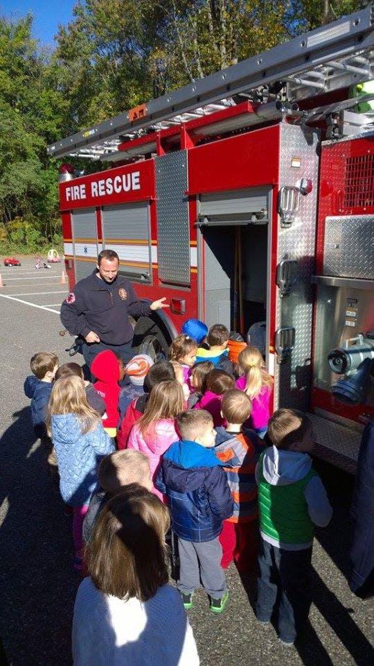 Firefighter showing children the inside of a fire truck