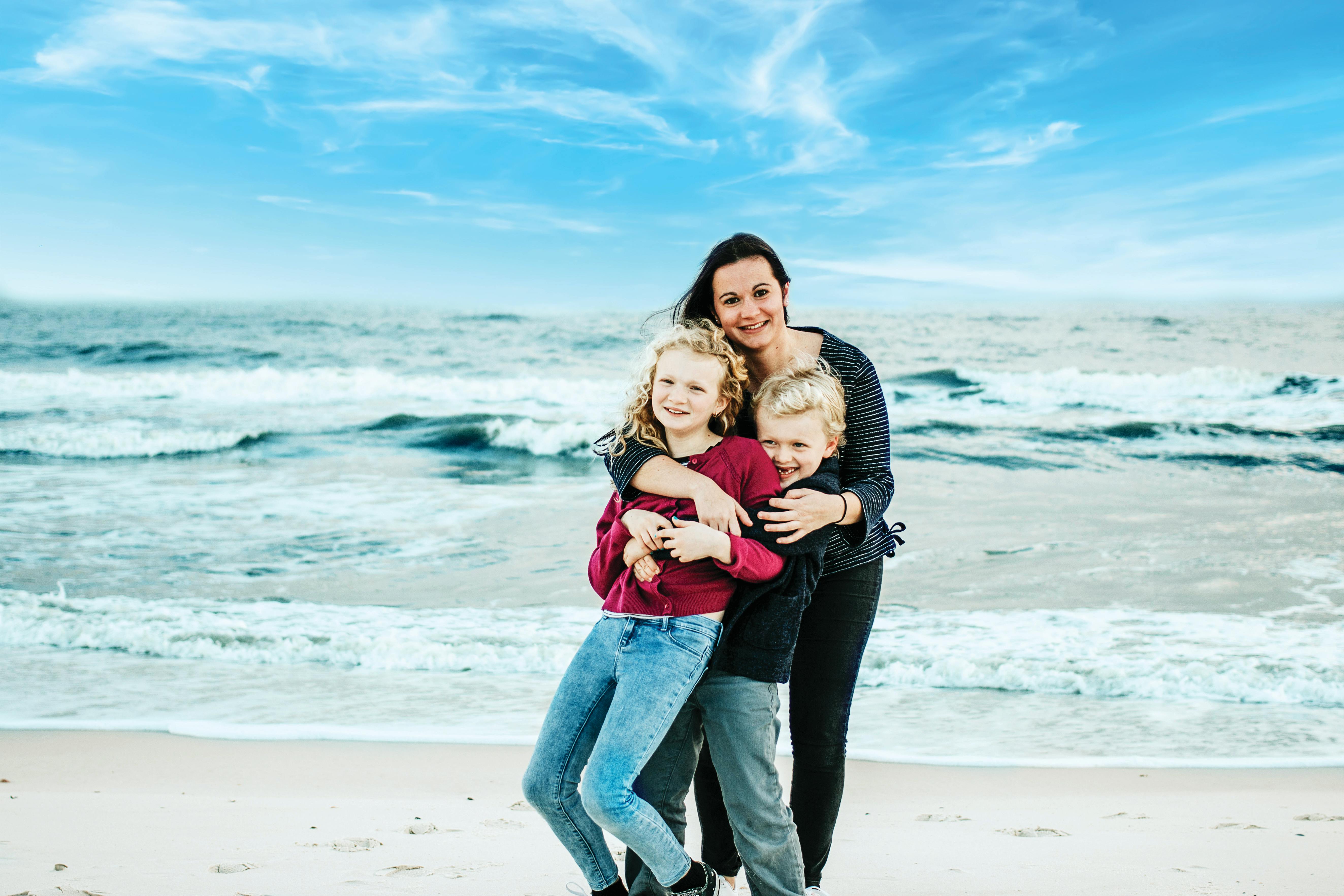 Person with two children on a beach