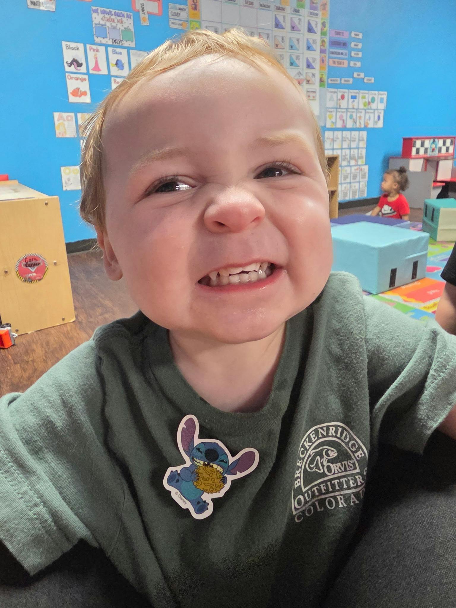 Close up of a young child grimacing in a classroom