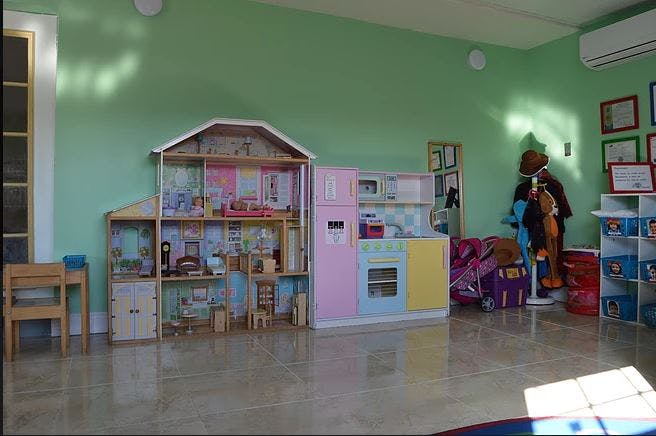 Dollhouse and play kitchen in a room