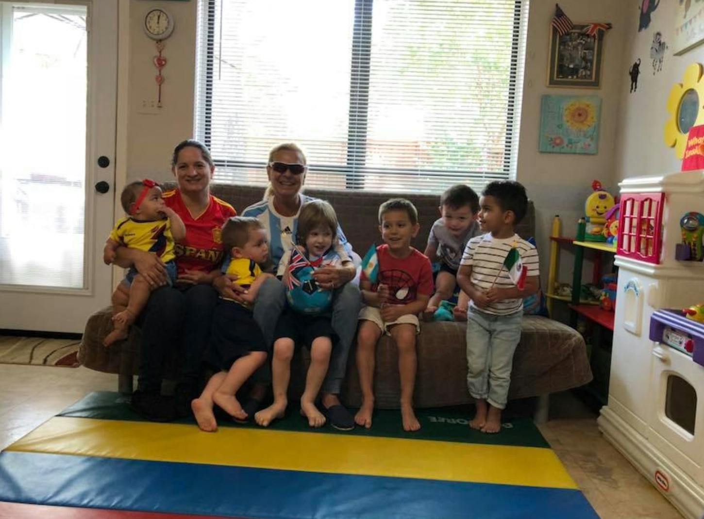 Two people and multiple children sitting on a couch