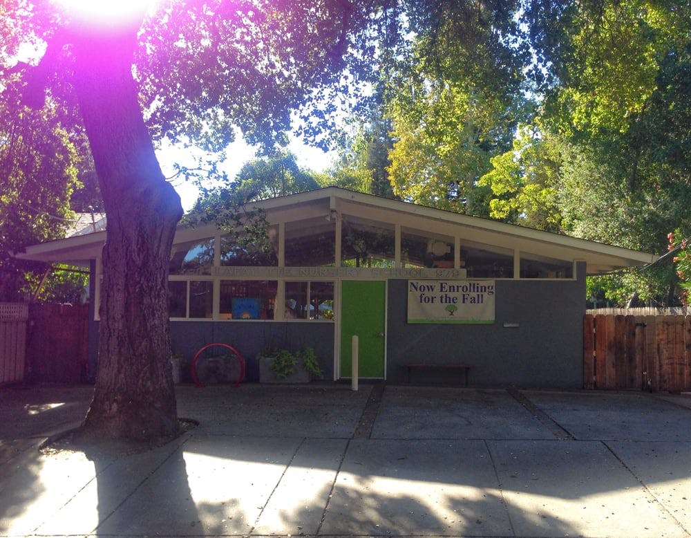 Building with a green door and a sign that says "Open Enrollment for the Fall"