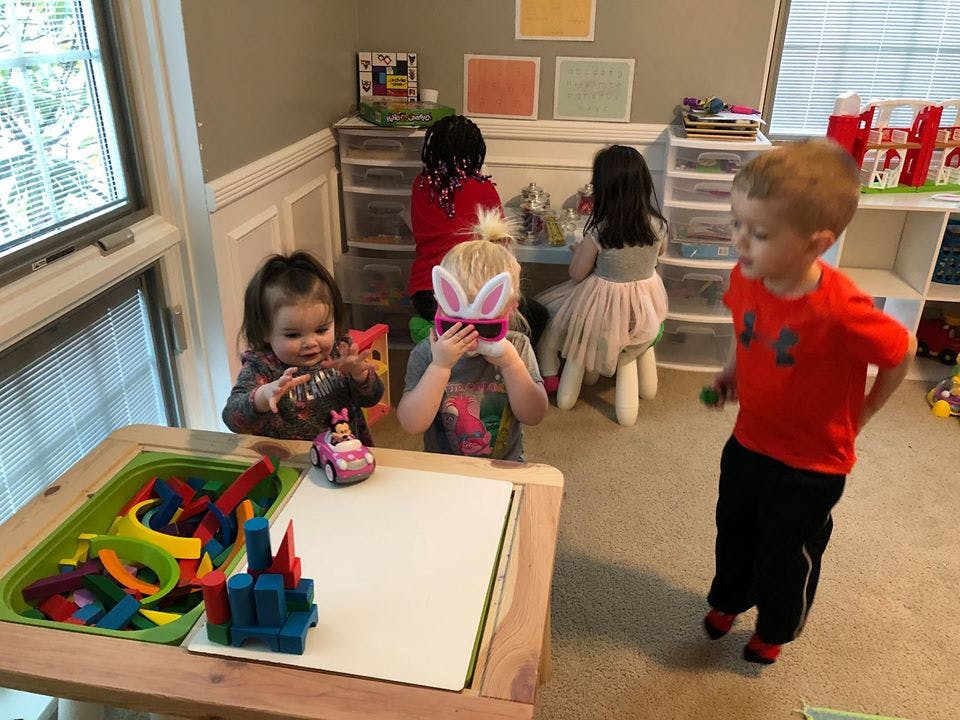 Children playing in a room, one child wearing bunny ears