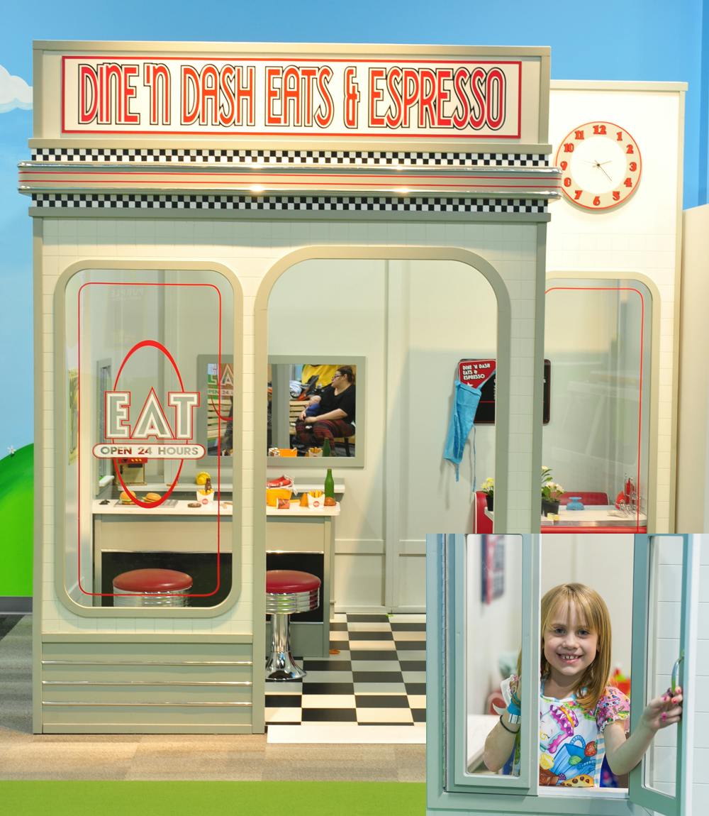 Child looking through a window of a play diner