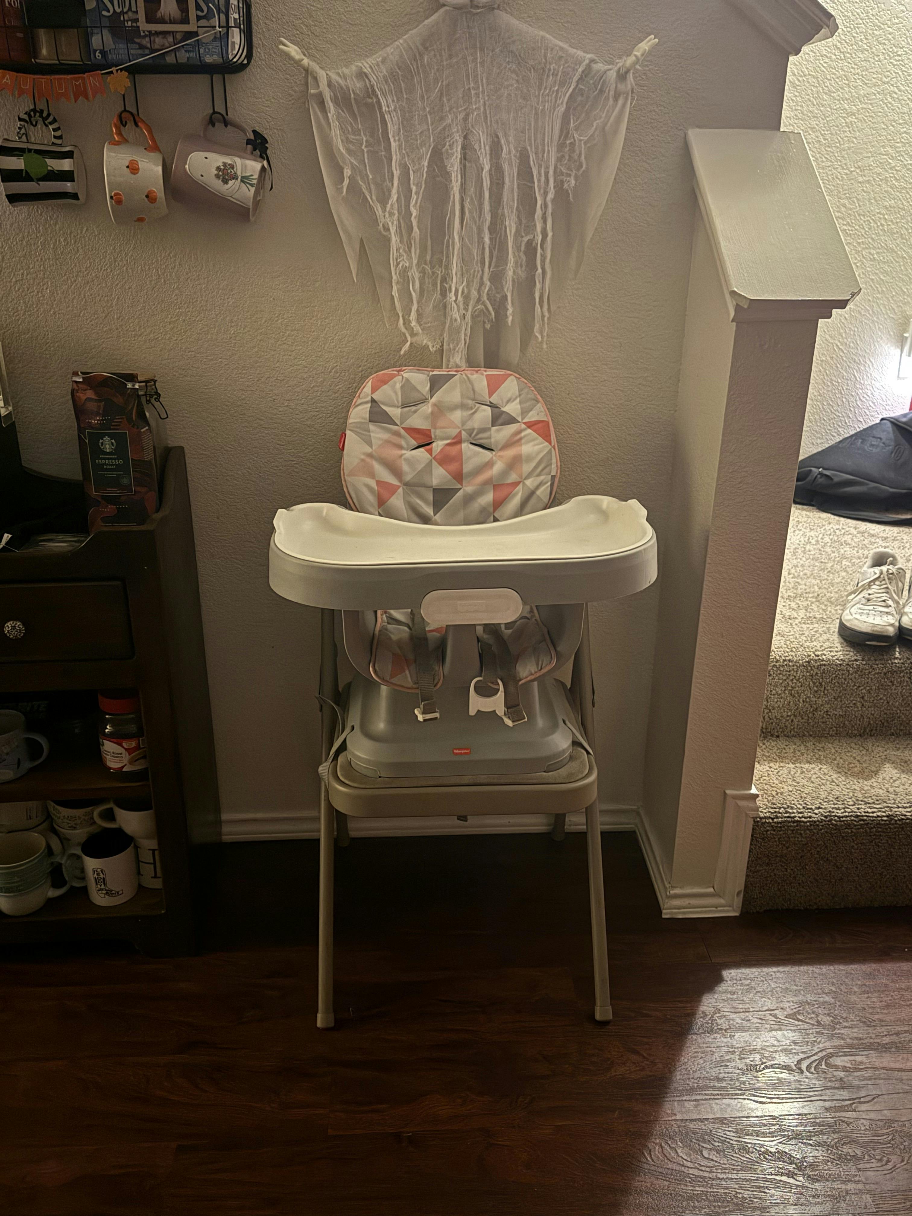 High chair with a patterned cushion and a white tray