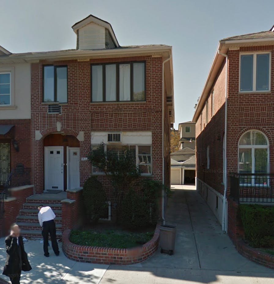 Brick building with a person bending over on the steps