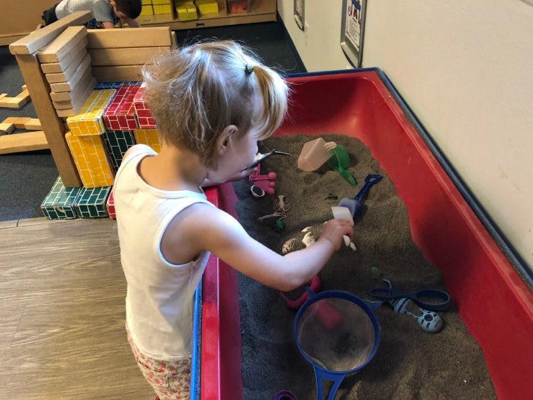 Child playing in a sand table