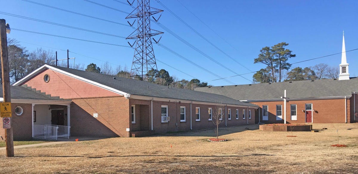 Brick buildings with a steeple and power lines overhead