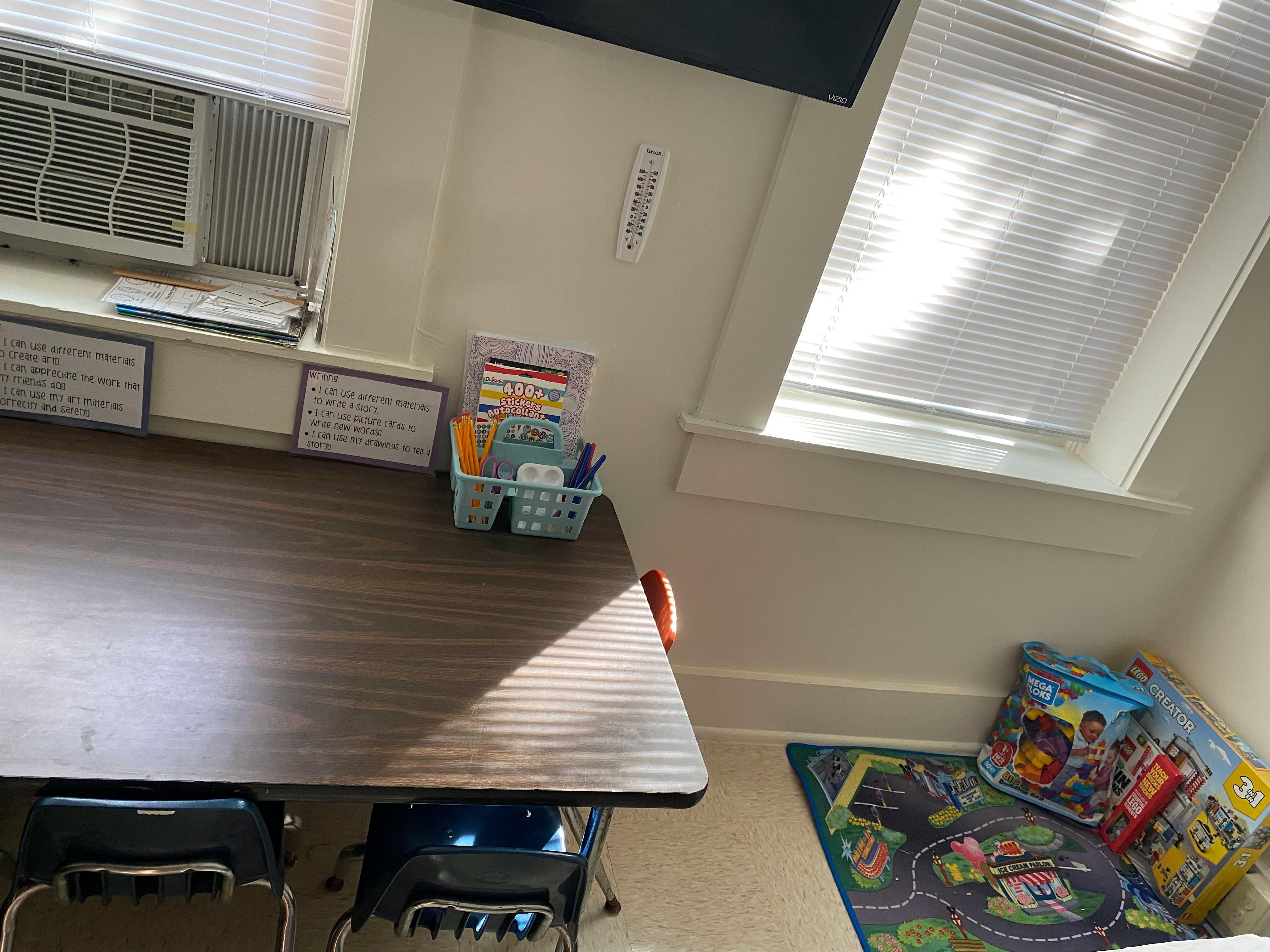 Classroom with a desk, window, and playmat