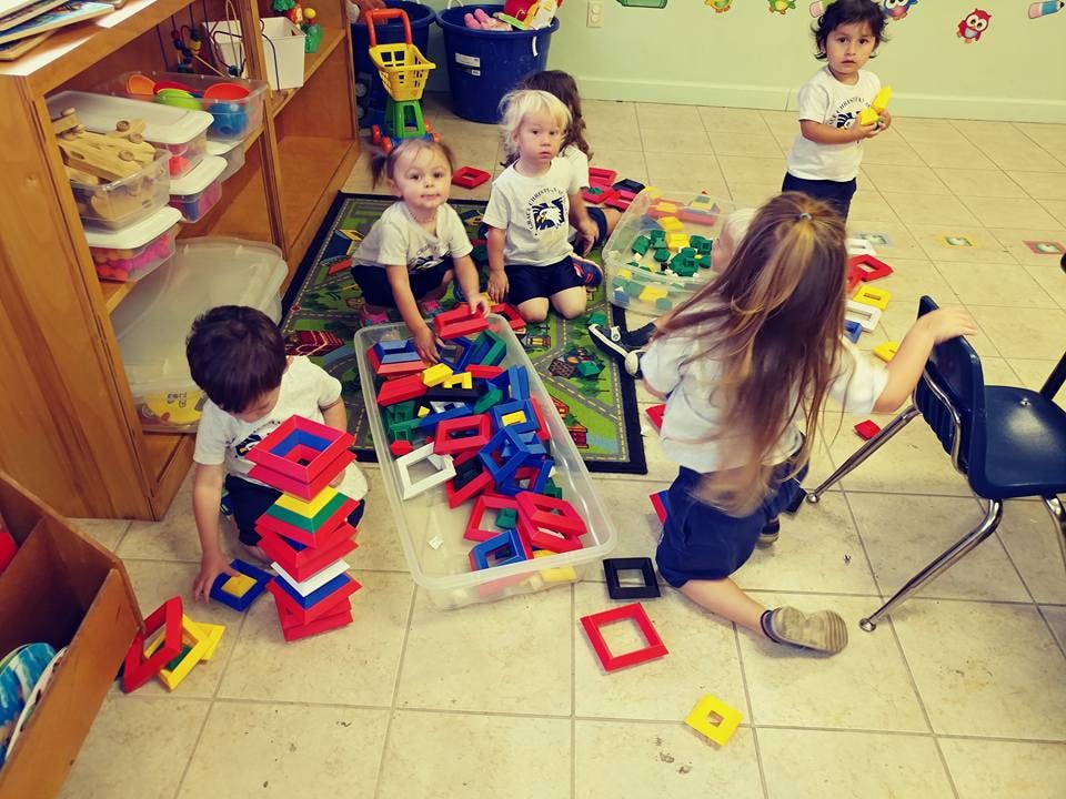Children playing with colorful building blocks on the floor