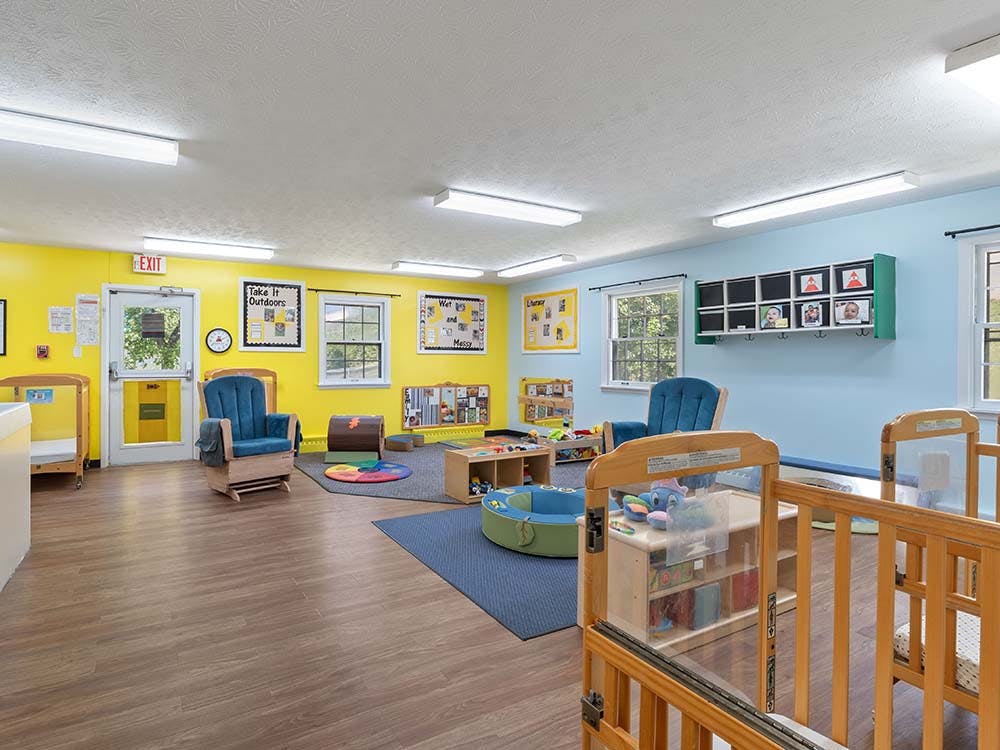 Classroom with cribs, two rocking chairs, and colorful walls