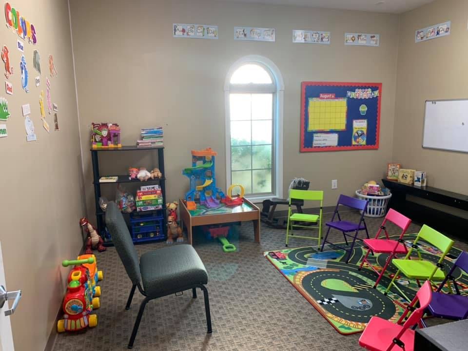 Children's play area with small chairs, toys, and a window