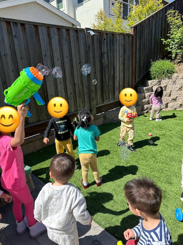 Children playing with a bubble gun in a backyard