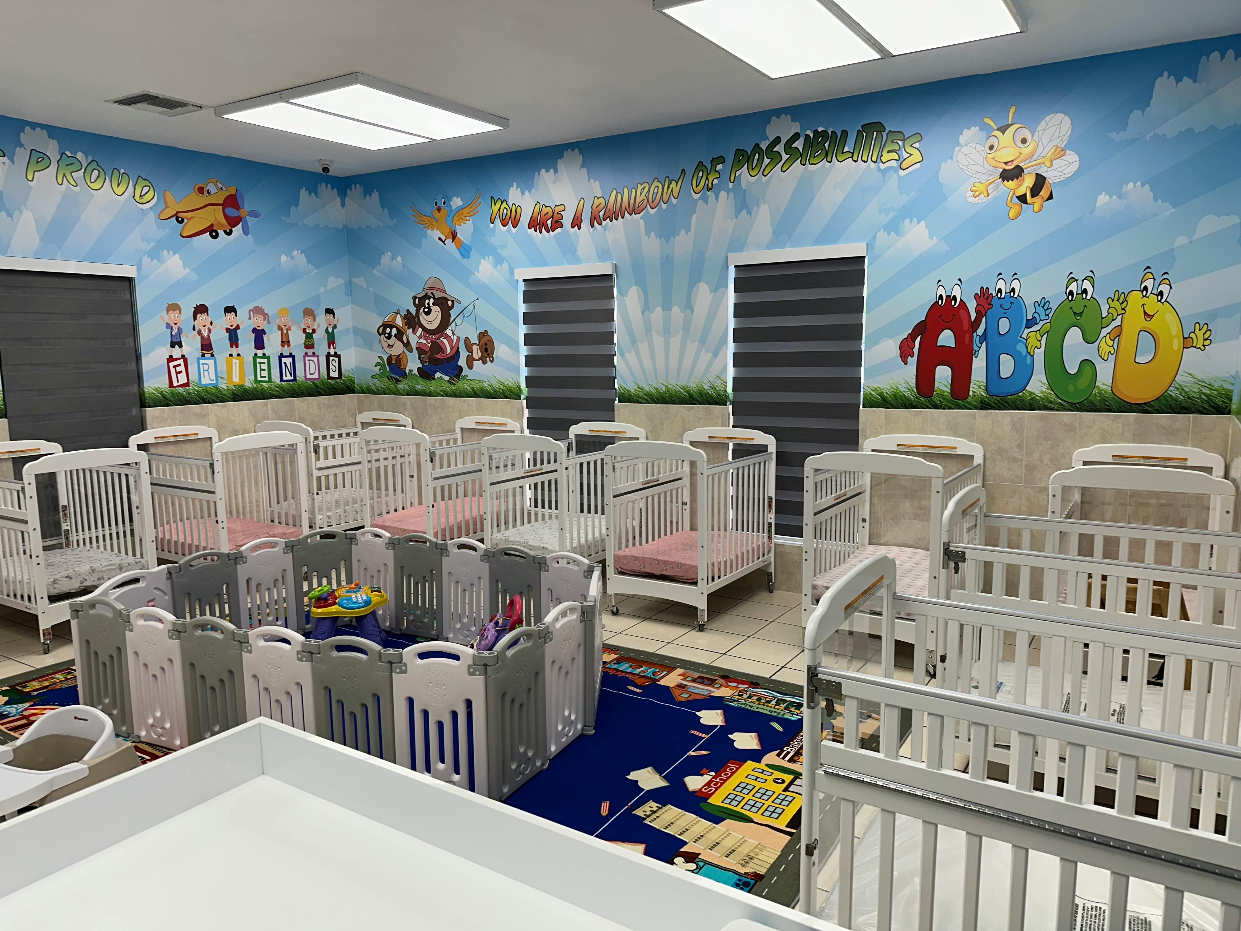 Nursery room with multiple cribs and a playpen