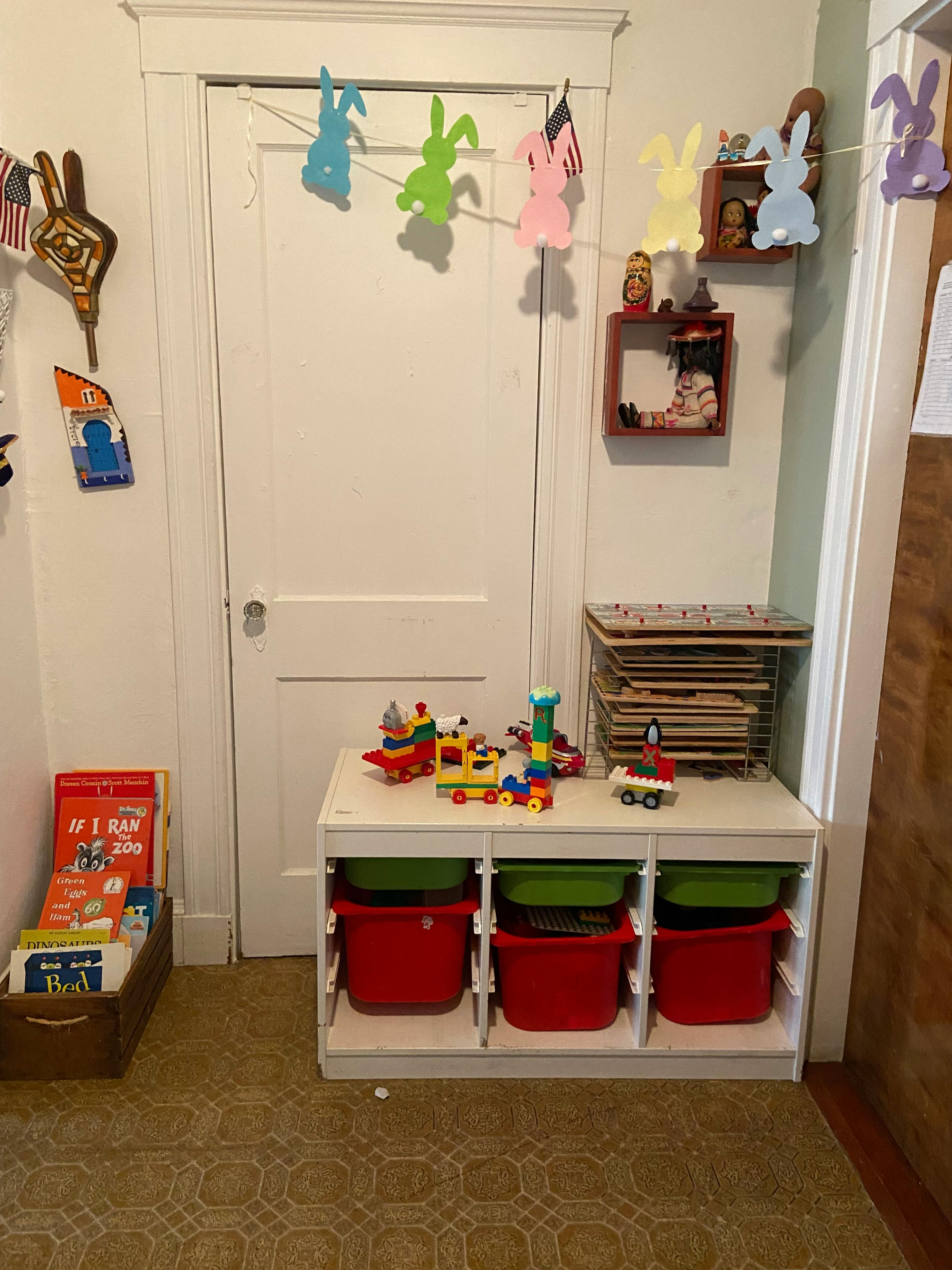 Children's toys on a storage unit with colorful bins