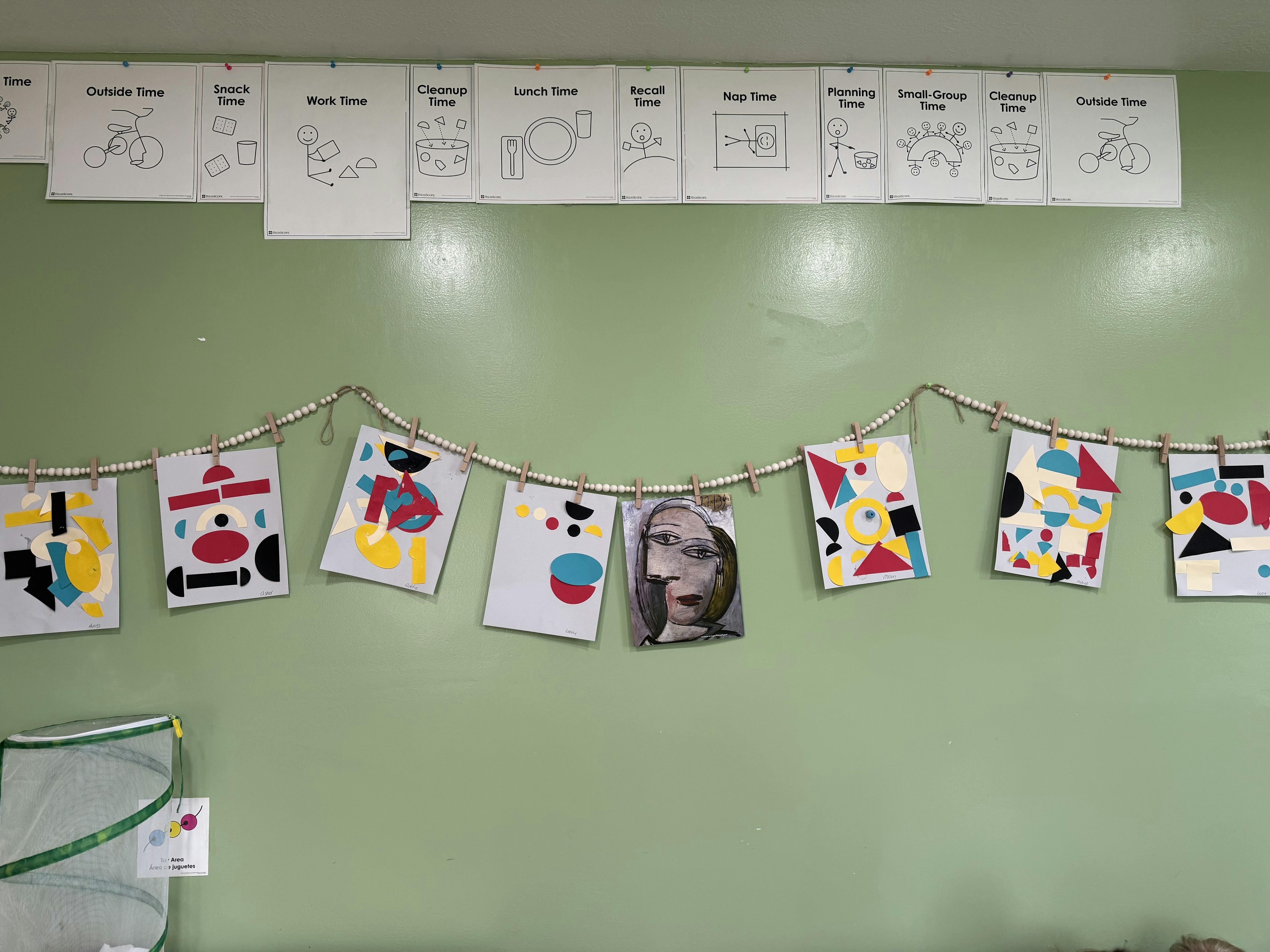 Classroom wall decorated with daily schedule signs and children artwork