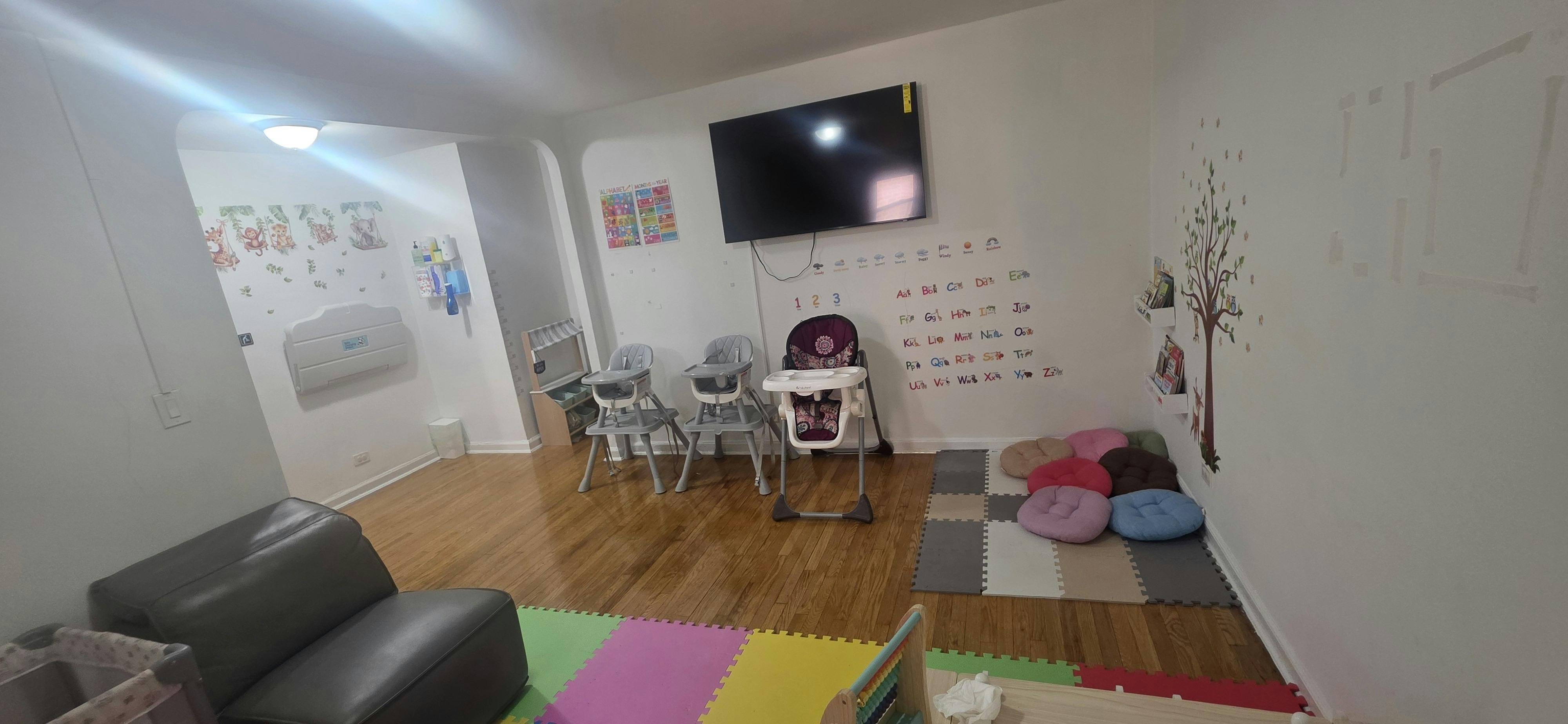 Childcare room with high chairs and a floor play area