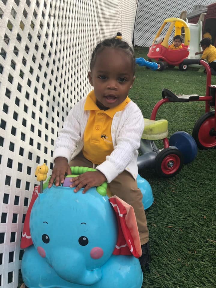 Child sitting on a blue elephant toy