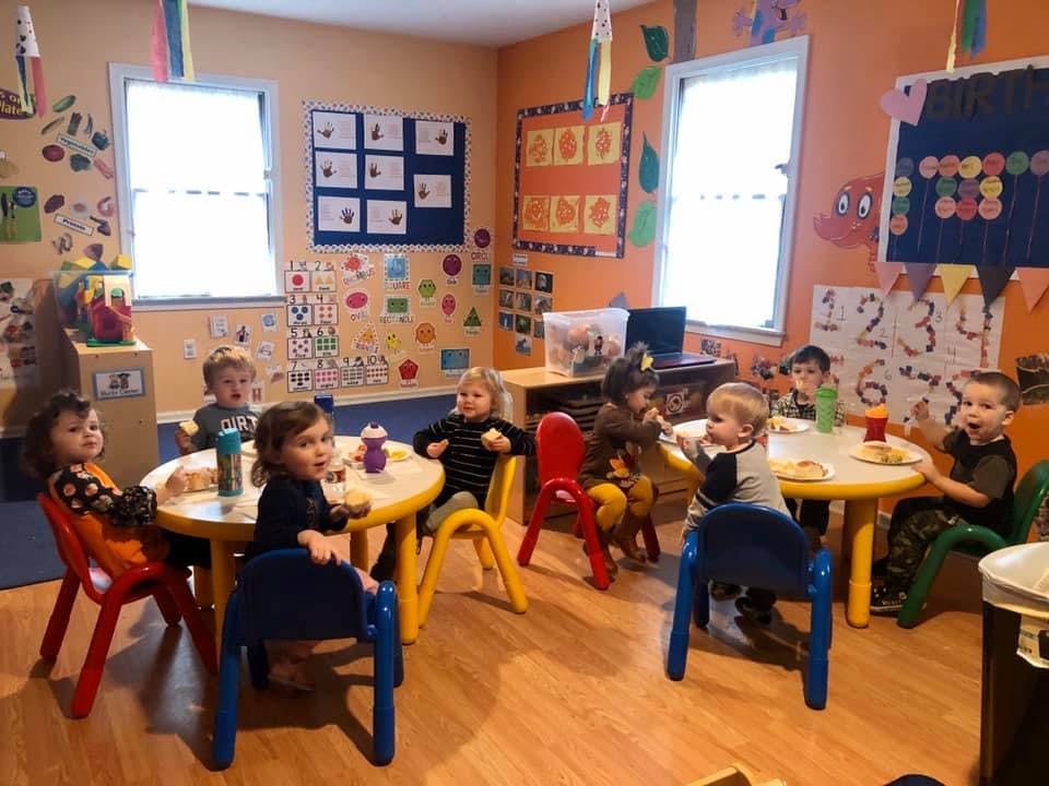 Children sitting at tables in a classroom