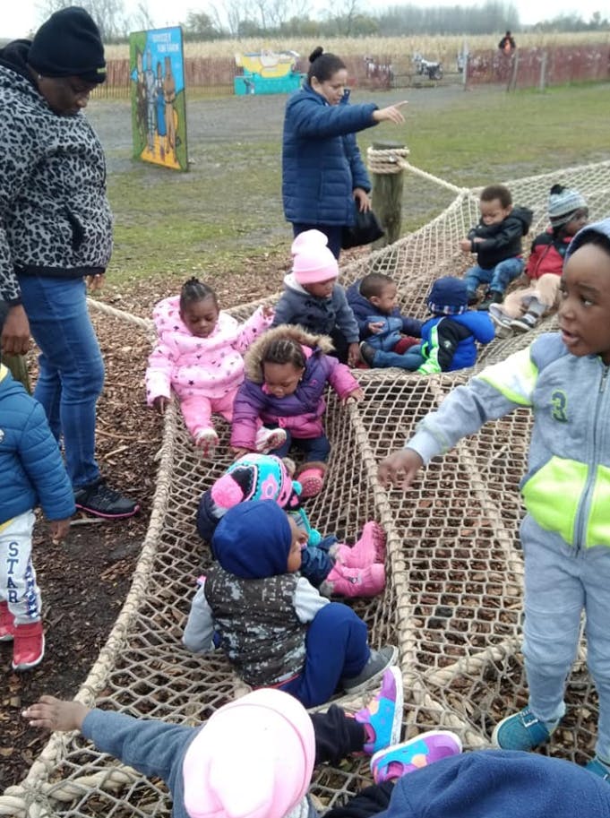Adults and children on a rope net structure outdoors