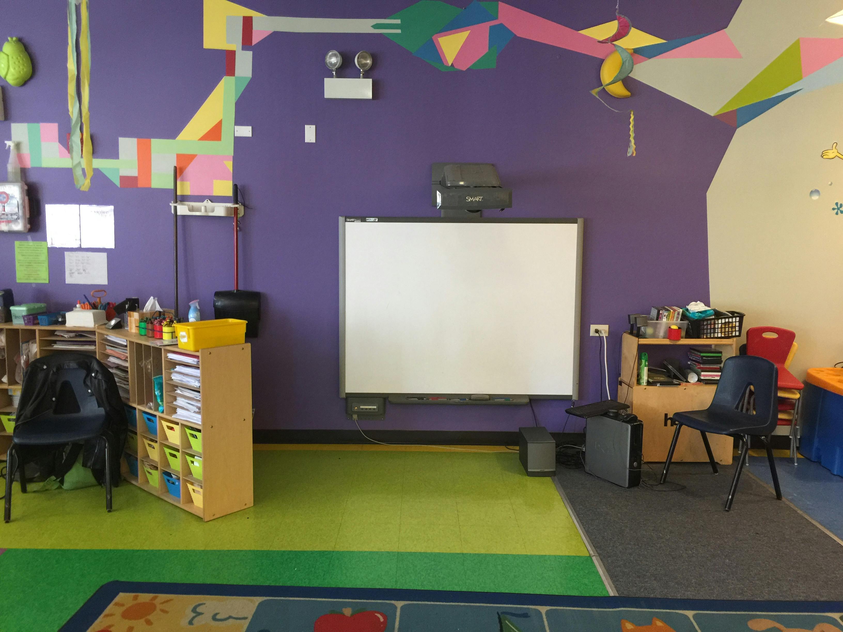 Classroom with purple walls, green floor, and a whiteboard