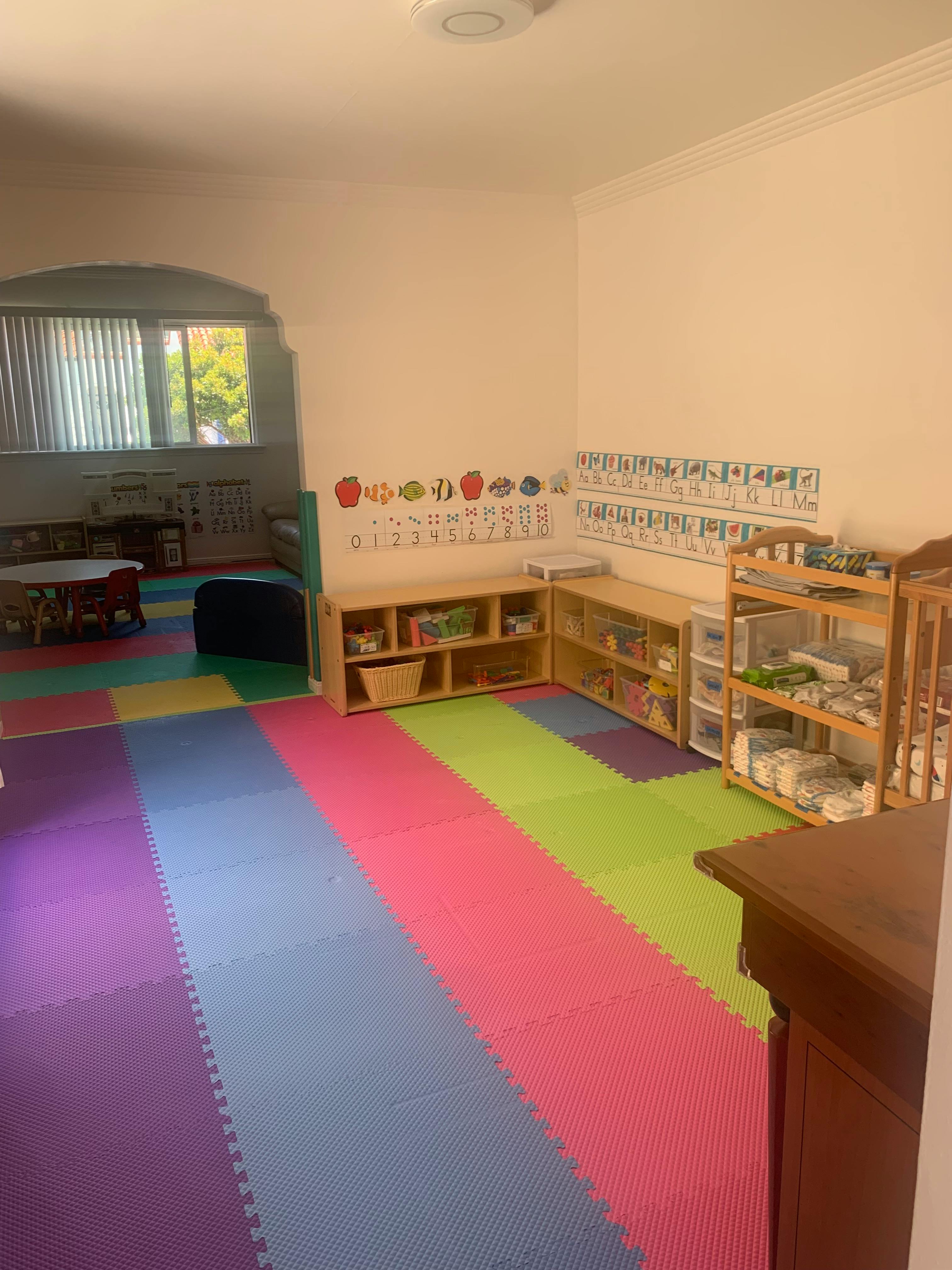 Playroom with colorful floor mats and shelves with toys