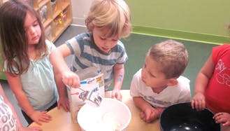 Children pouring from a bag into a bowl